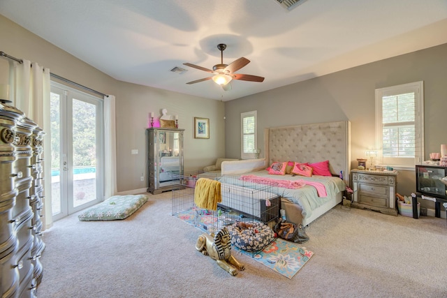 carpeted bedroom featuring french doors, multiple windows, and access to outside