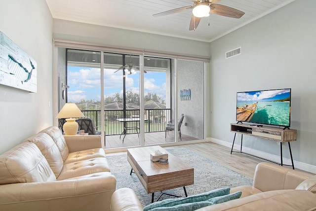 living room with ceiling fan, ornamental molding, and light wood-type flooring