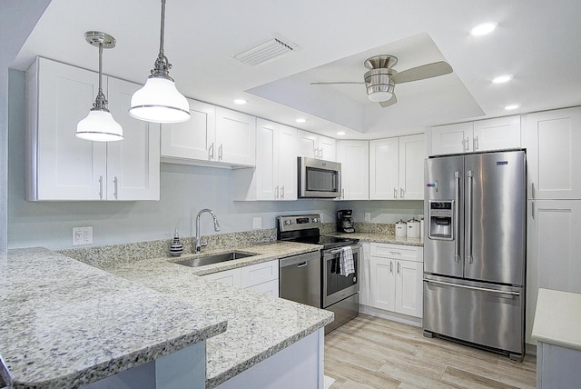 kitchen featuring appliances with stainless steel finishes, kitchen peninsula, and white cabinets