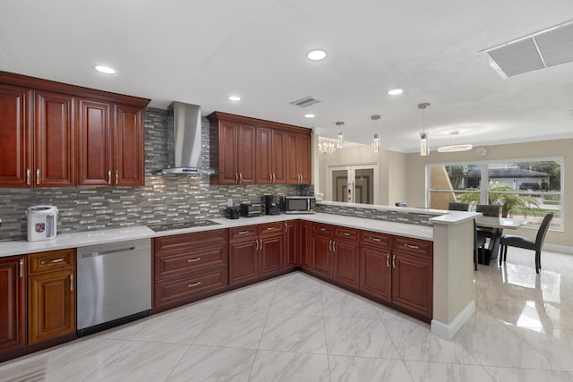 kitchen with tasteful backsplash, hanging light fixtures, kitchen peninsula, stainless steel appliances, and wall chimney range hood