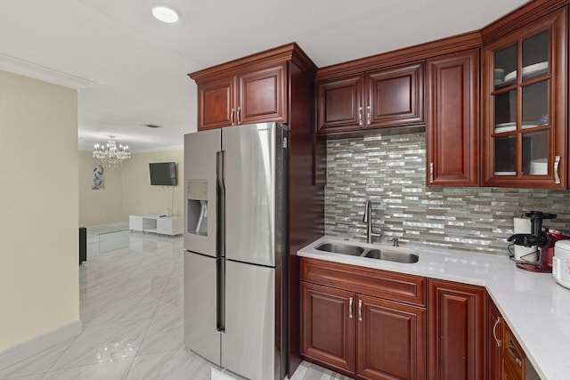 kitchen with pendant lighting, sink, stainless steel refrigerator with ice dispenser, tasteful backsplash, and ornamental molding