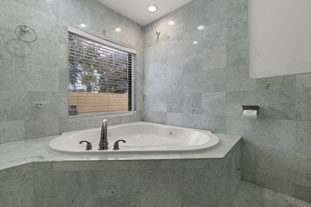 bathroom with tile walls and tiled tub