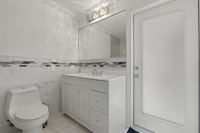 bathroom with vanity, ornamental molding, tile walls, and toilet