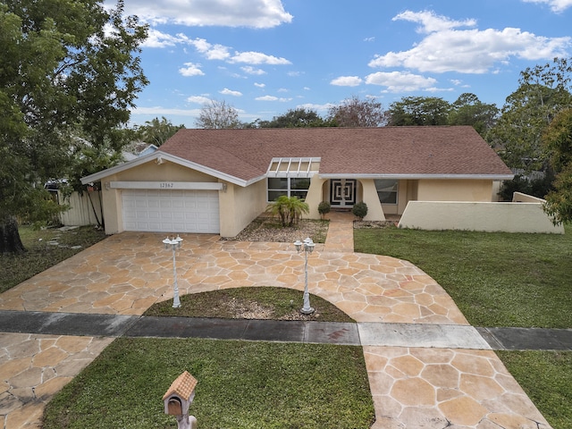 ranch-style house featuring a garage and a front yard