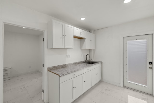 kitchen featuring white cabinetry and sink