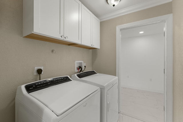 clothes washing area with crown molding, cabinets, and washer and clothes dryer