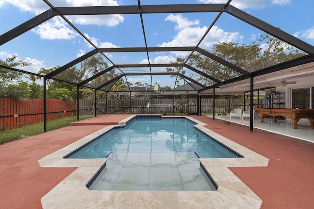 view of swimming pool featuring a patio, ceiling fan, and glass enclosure