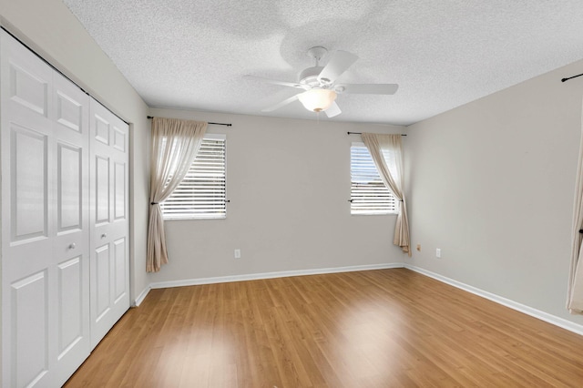 3215 NW 12th St, Delray Beach, FL 33445 - unfurnished bedroom with a textured ceiling, light wood-style flooring, a closet, baseboards, and ceiling fan