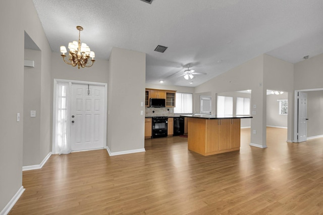 3215 NW 12th St, Delray Beach, FL 33445 - kitchen featuring black appliances, open floor plan, a chandelier, light wood-style floors, and a textured ceiling