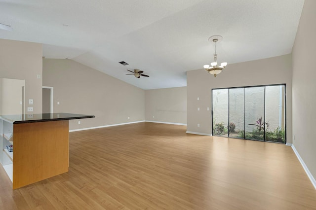 3215 NW 12th St, Delray Beach, FL 33445 - unfurnished living room featuring light wood-style floors, a chandelier, lofted ceiling, a ceiling fan, and baseboards
