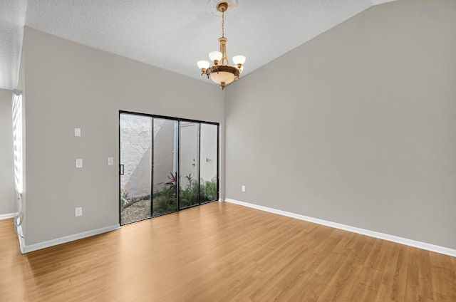 3215 NW 12th St, Delray Beach, FL 33445 - spare room featuring a chandelier, light wood finished floors, baseboards, lofted ceiling, and a textured ceiling