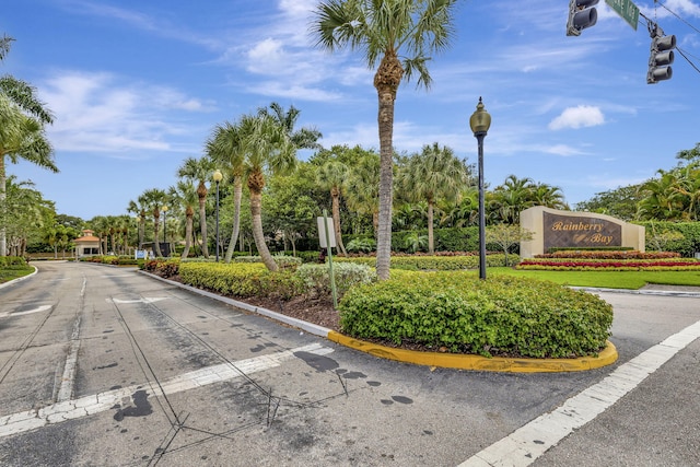 3215 NW 12th St, Delray Beach, FL 33445 - view of asphalt road featuring traffic lights, street lighting, curbs, traffic signs, and view of scattered trees