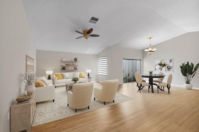 3215 NW 12th St, Delray Beach, FL 33445 - living area with vaulted ceiling, light wood-type flooring, a textured ceiling, baseboards, and a chandelier