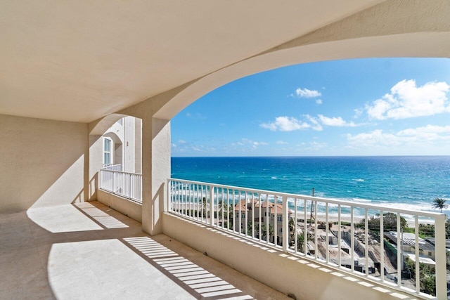 balcony featuring a water view and a view of the beach