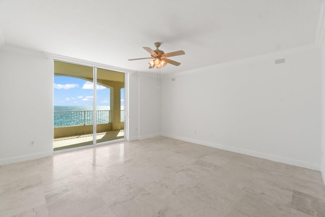 spare room featuring ceiling fan, a water view, crown molding, and expansive windows