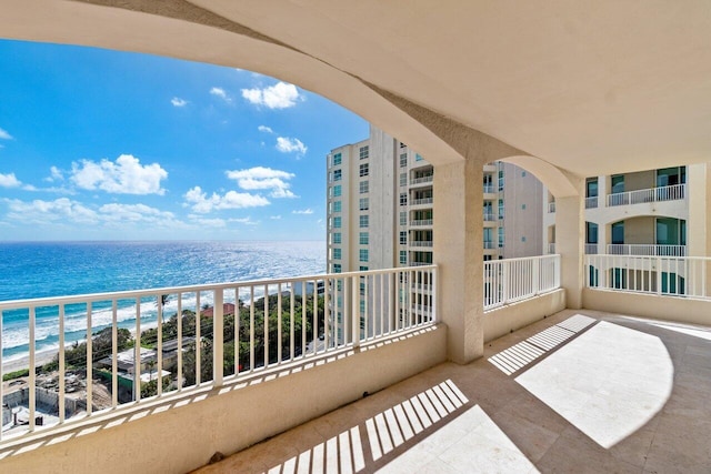 balcony with a water view and a beach view