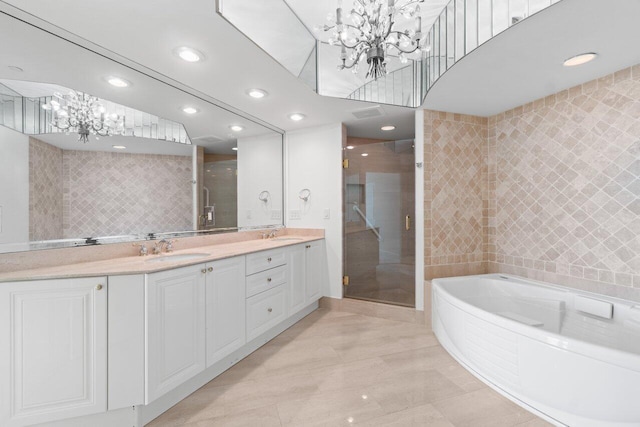 bathroom with vanity, an inviting chandelier, and independent shower and bath