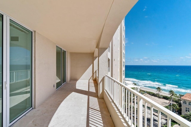 balcony with a water view and a beach view