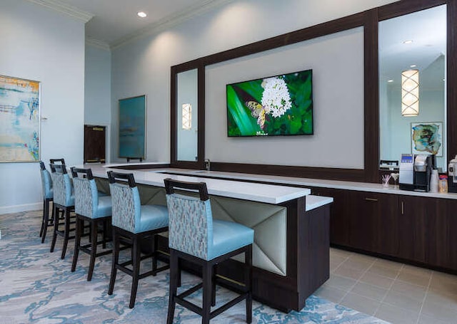 bar with crown molding, light tile patterned flooring, and dark brown cabinetry