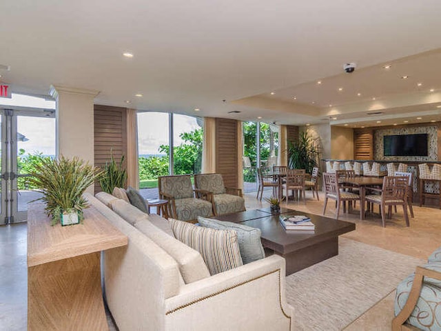 living room with a wall of windows and a raised ceiling