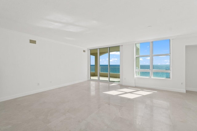 empty room with a water view, crown molding, and floor to ceiling windows