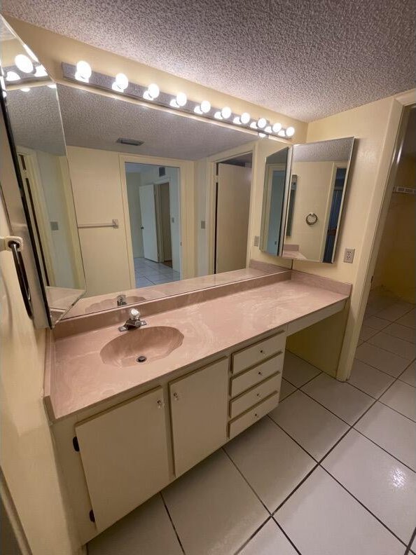 bathroom featuring tile patterned flooring, vanity, and a textured ceiling