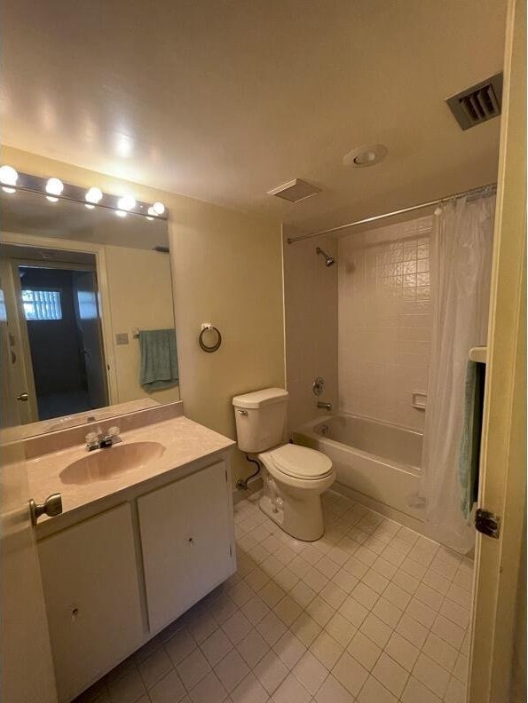 full bathroom with shower / bathtub combination with curtain, vanity, tile patterned floors, and toilet