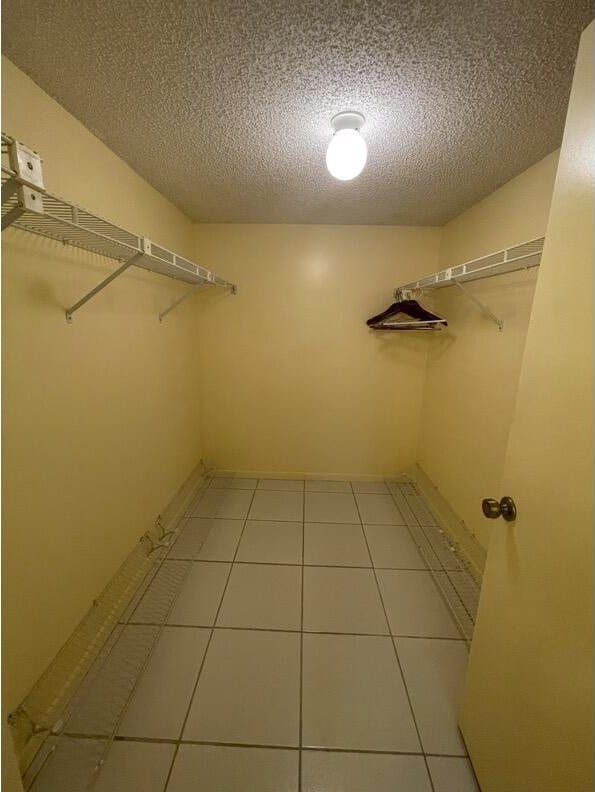 spacious closet with light tile patterned floors