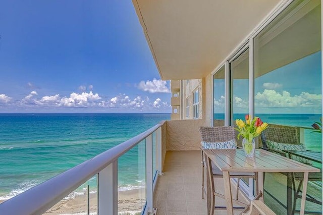 balcony featuring a beach view and a water view