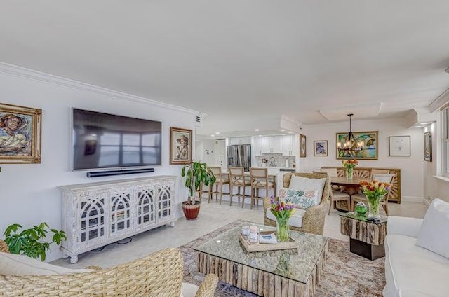 living room with crown molding and an inviting chandelier