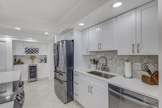 kitchen featuring wine cooler, sink, white cabinetry, crown molding, and stainless steel appliances