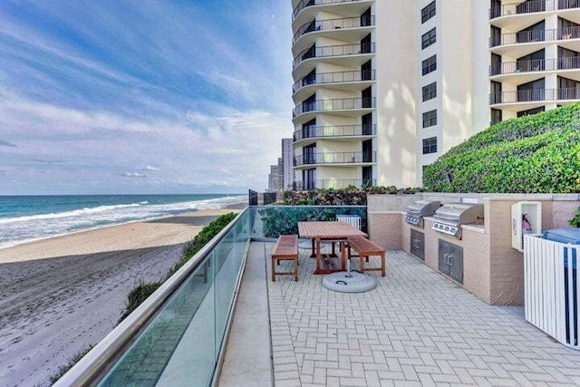 exterior space featuring a water view, a beach view, and grilling area