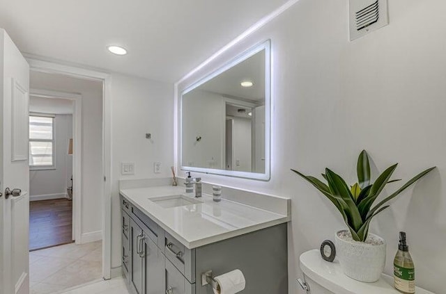 bathroom featuring tile patterned flooring, vanity, and toilet