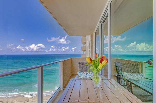 balcony featuring a beach view and a water view