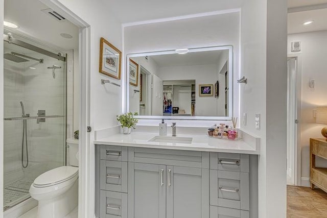 bathroom featuring vanity, an enclosed shower, and toilet