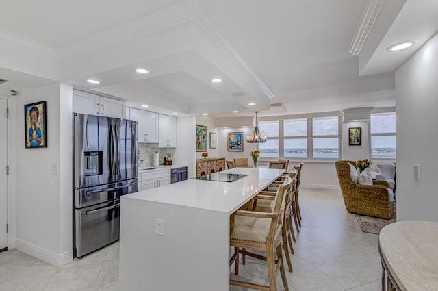 kitchen with decorative light fixtures, white cabinetry, crown molding, a kitchen breakfast bar, and stainless steel refrigerator with ice dispenser