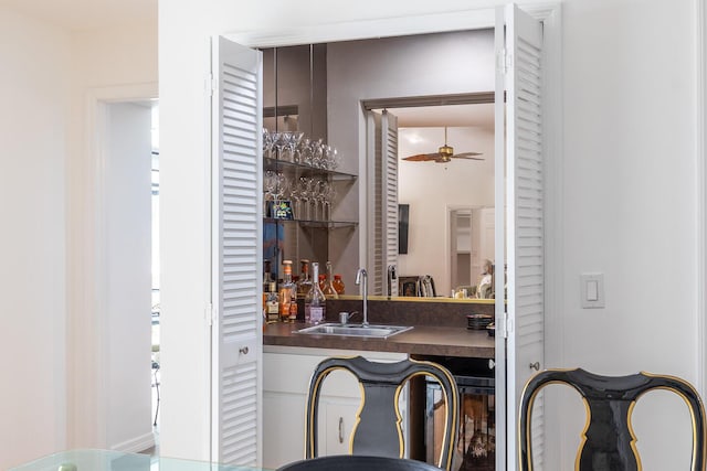 bar featuring wet bar, a sink, and ceiling fan