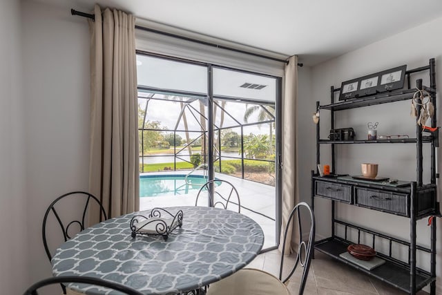 tiled dining room featuring a sunroom