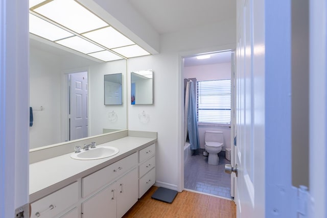 bathroom featuring shower / tub combo, baseboards, toilet, wood finished floors, and vanity