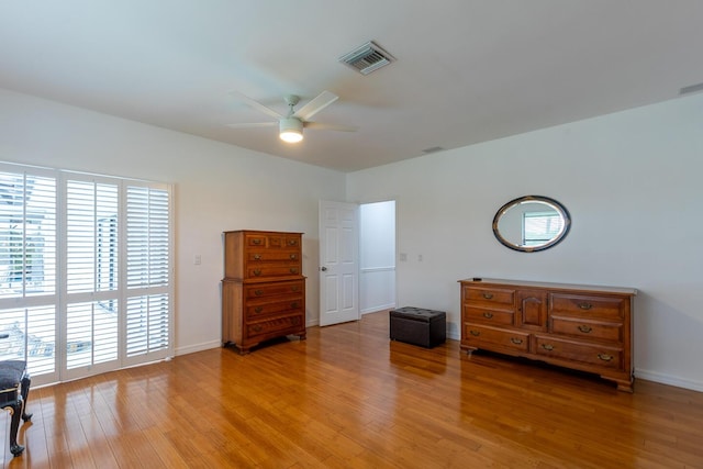 bedroom featuring a ceiling fan, visible vents, light wood-style flooring, and baseboards