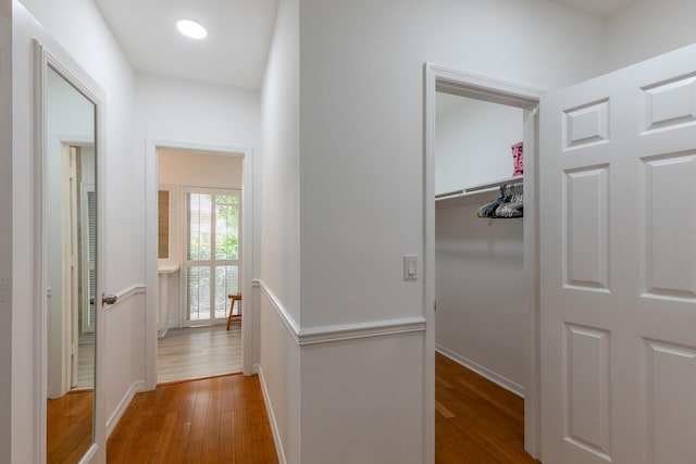 hallway with wood-type flooring and baseboards