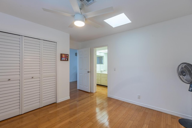 unfurnished bedroom featuring baseboards, visible vents, ceiling fan, light wood-type flooring, and a closet