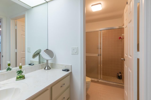 bathroom featuring vanity, a shower stall, toilet, and tile patterned floors