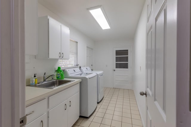 clothes washing area featuring cabinet space, a sink, washer and clothes dryer, and light tile patterned flooring