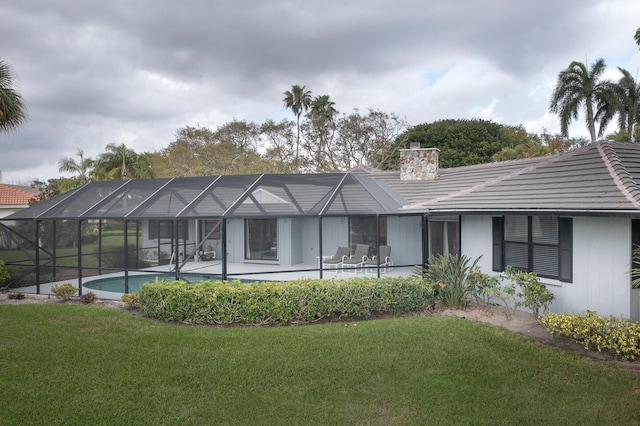 rear view of property featuring an outdoor pool, a lanai, a tile roof, and a yard