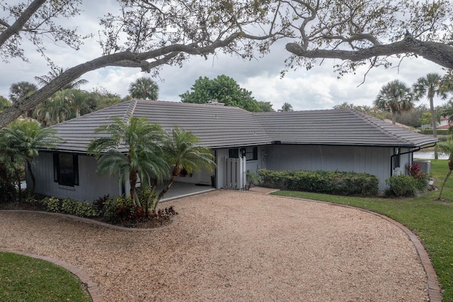 view of front of property featuring driveway and a tiled roof