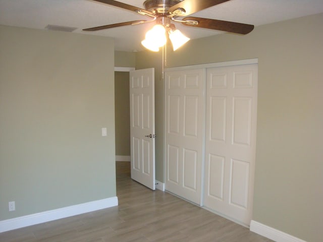 unfurnished bedroom featuring light hardwood / wood-style flooring, a closet, and ceiling fan