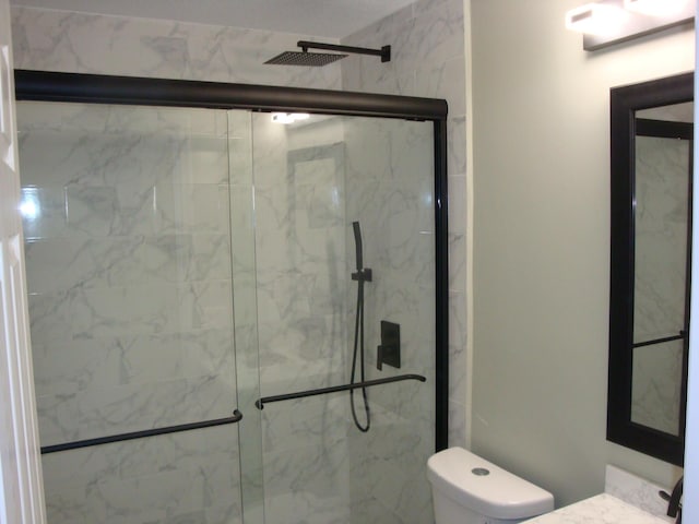 bathroom with vanity, an enclosed shower, and toilet