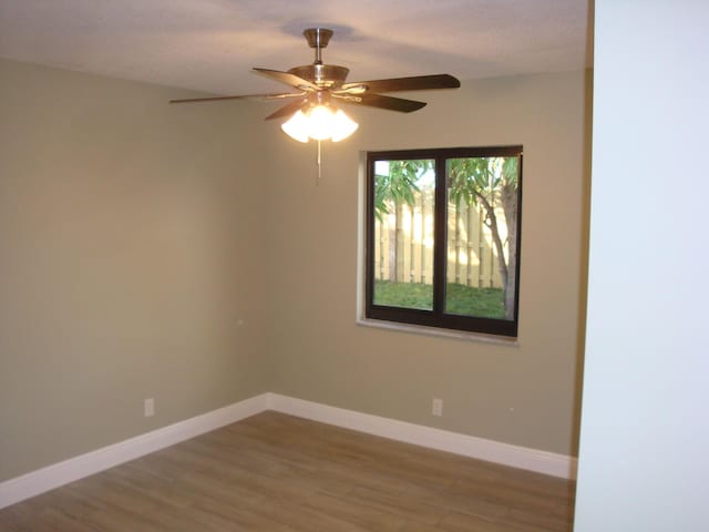 spare room with hardwood / wood-style floors and ceiling fan