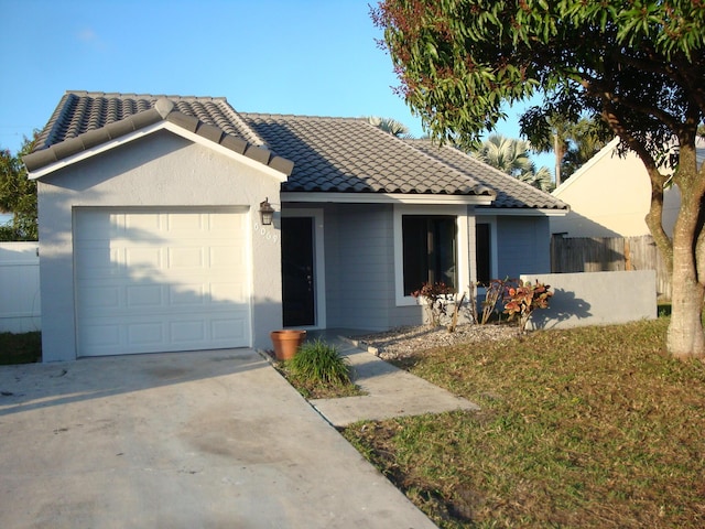 ranch-style home with a garage and a front yard